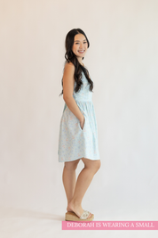 Woman wearing a light blue dress with a white background
