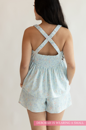 Child wearing a light blue romper with star pattern on a plain background