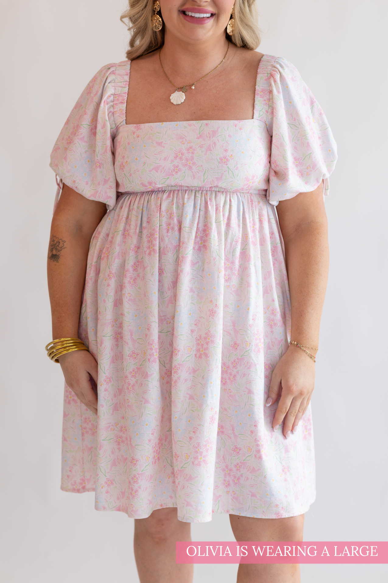 Woman wearing a floral dress with a plain background