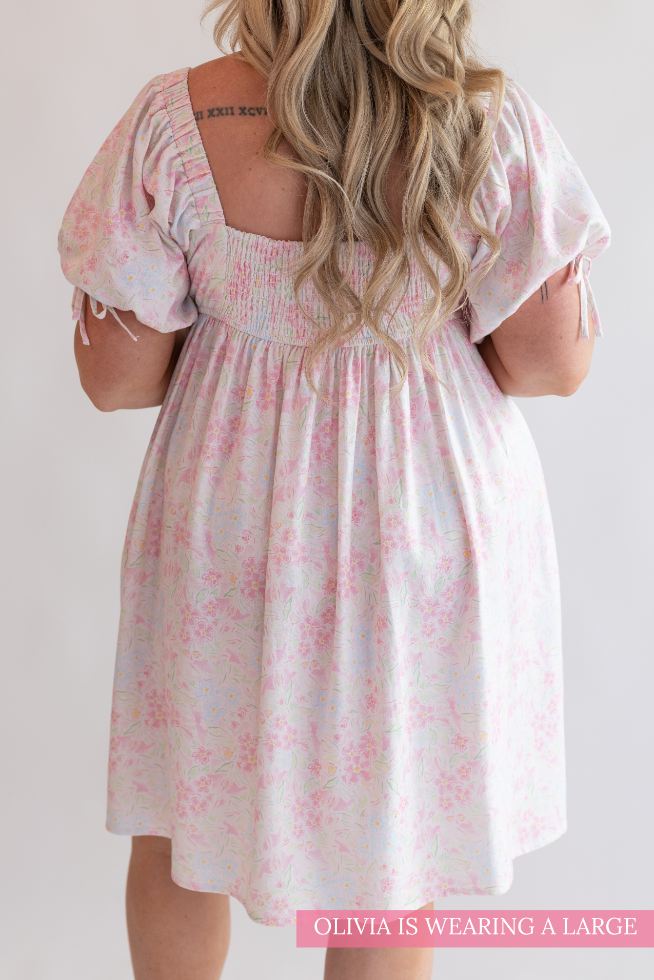 Woman wearing a floral dress with a plain background