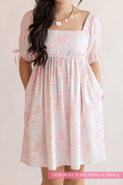 Woman wearing a floral dress on a plain background