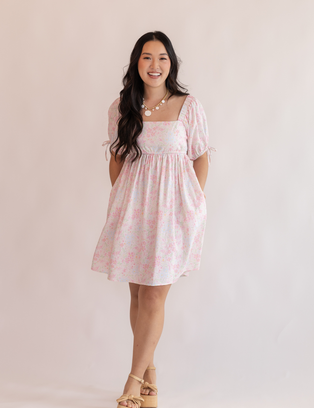 Woman wearing a pink dress with a white background