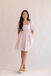 Woman wearing a pink dress with a white background