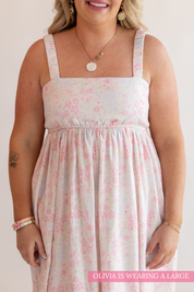 Woman wearing a floral dress with text indicating she is wearing a large size.