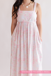 Woman wearing a floral dress on a plain background